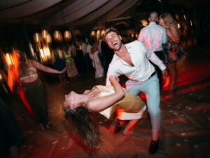 Groom dips bride on the dance floor.